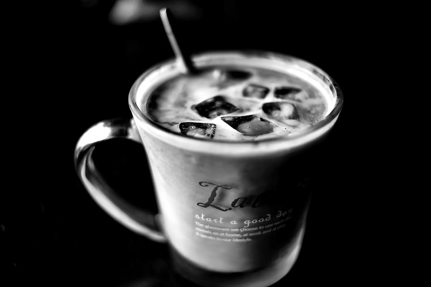 Black and white iced coffee in glass mug with text