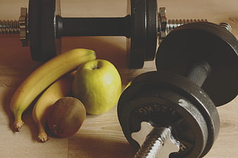 Dumbbells and Fresh Fruit on Wooden Surface for Fitness Concept