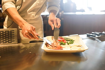 Chef preparing fresh seafood and vegetables on a teppanyaki grill