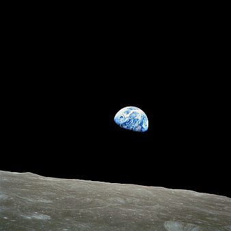 Earth rising over the lunar horizon in deep space