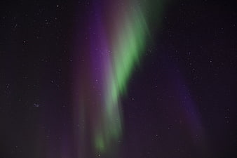 Vibrant Green and Purple Aurora Borealis in Starry Night Sky