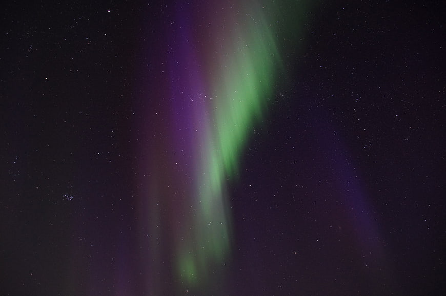 Vibrant Green and Purple Aurora Borealis in Starry Night Sky