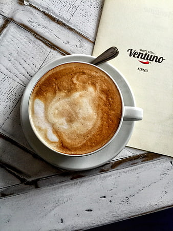 Flat lay cappuccino on rustic white wooden table with menu