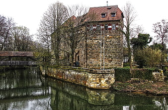 Historic stone castle with moat and wooden bridge in Bavaria