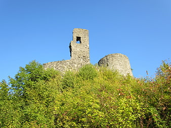 Ancient stone castle ruins on a hill with blue sky