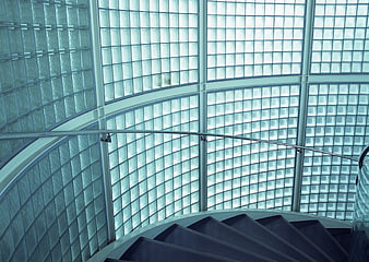 Modern spiral staircase with glass block wall background