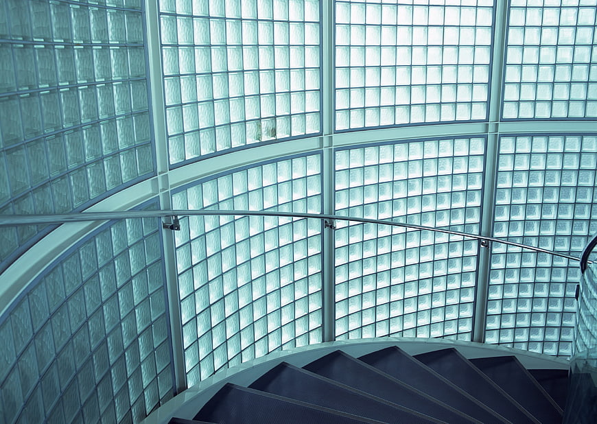 Modern spiral staircase with glass block wall background