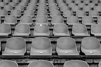 Rows of empty stadium seats in black and white