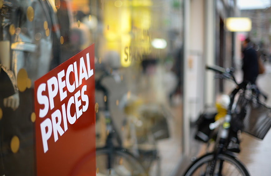 Red Special Prices Sign On Store Window With Blurred Street Background