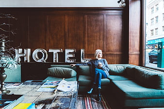 Woman relaxing on couch in hotel lobby with coffee