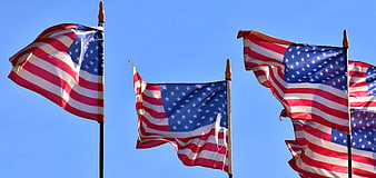 American flags waving against a clear blue sky