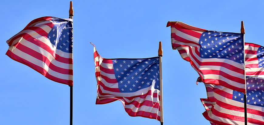 American flags waving against a clear blue sky