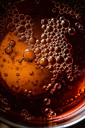 Macro shot of golden honey with bubbles in a bowl