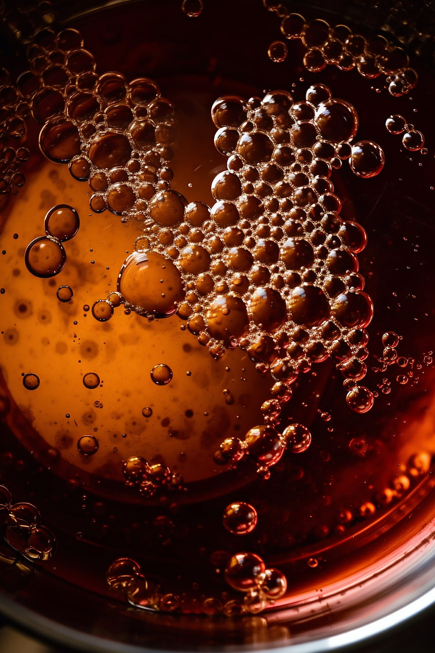 Macro shot of golden honey with bubbles in a bowl