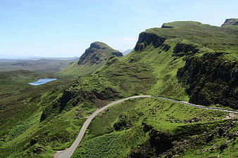 Winding Road Through Green Highland Mountains and Lake