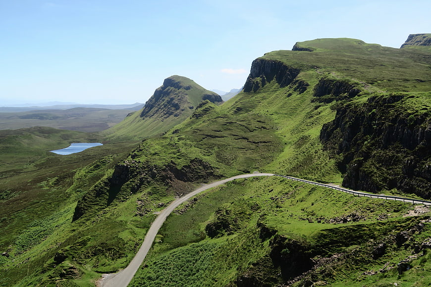 Winding Road Through Green Highland Mountains and Lake