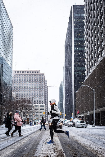 Woman Running in Snowy City Street