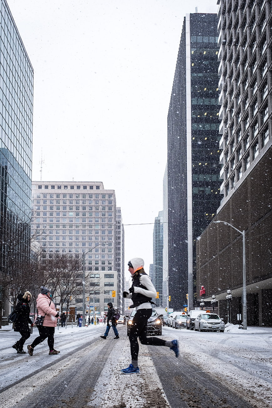 Woman Running in Snowy City Street