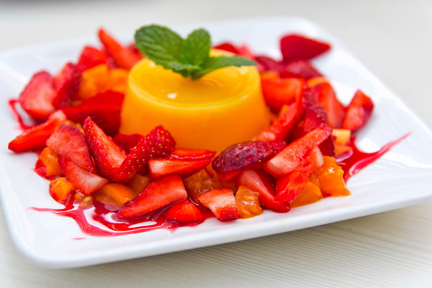Yellow Pudding Dessert with Fresh Strawberries and Mint