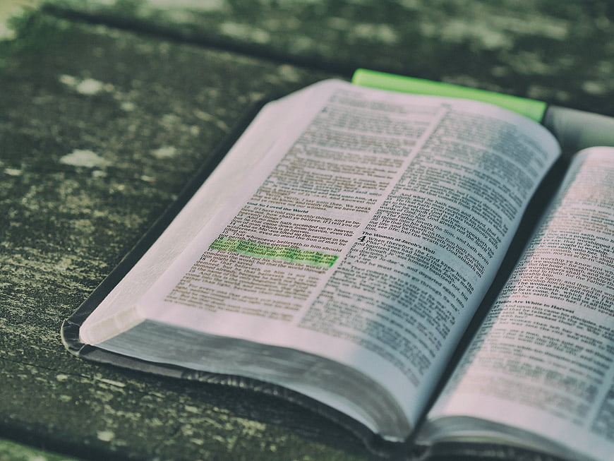 Open Bible with Highlighted Verses on Textured Surface