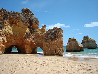 Golden rock formations and arches on a sunny Algarve beach