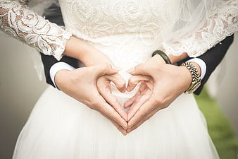 Wedding couple hands forming heart shape close up
