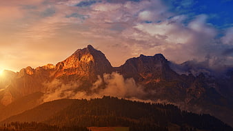 Majestic Mountain Peaks at Sunset with Golden Light and Clouds