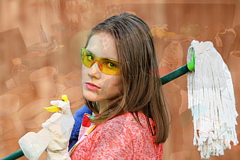 Woman in Safety Goggles Holding Mop and Spray Bottle in Cluttered Room