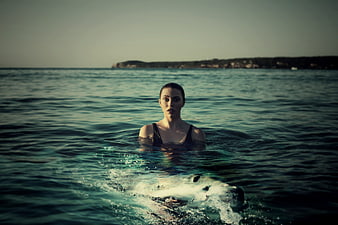 Woman swimming in ocean with great white shark approaching