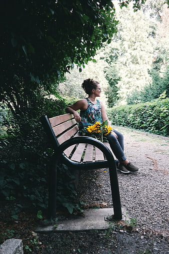 Woman with Sunflowers Sitting on Park Bench