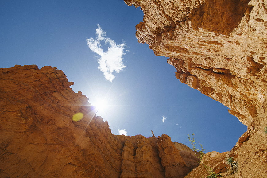 Low angle view of red rock canyon walls against blue sky