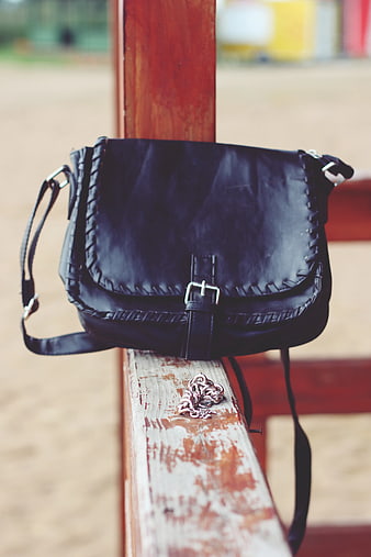 Black Leather Handbag on Wooden Bench