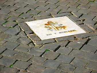 Pope John Paul II Memorial Tile on Cobblestone Street