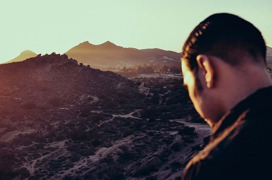 Man Looking at Mountain Landscape at Sunset
