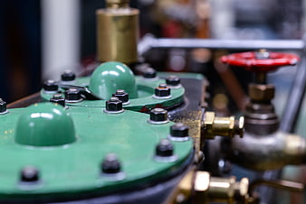 Close-up of green industrial machinery with brass fittings