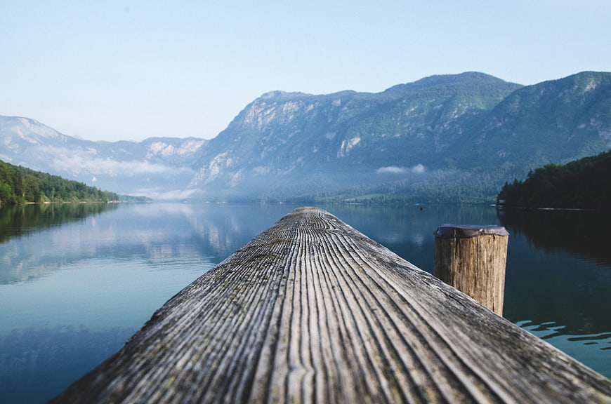 Serene Alpine Lake Landscape With Wooden Pier And Mountain Reflections