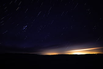 Long Exposure Star Trails Over Silhouette Landscape at Night