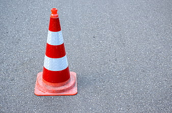 Orange traffic cone on asphalt road with copyspace