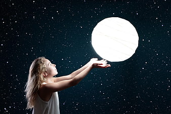 Young girl reaching for a glowing moon against a starry night sky