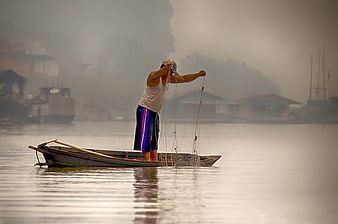 Fisherman Casting Net in Misty Morning River