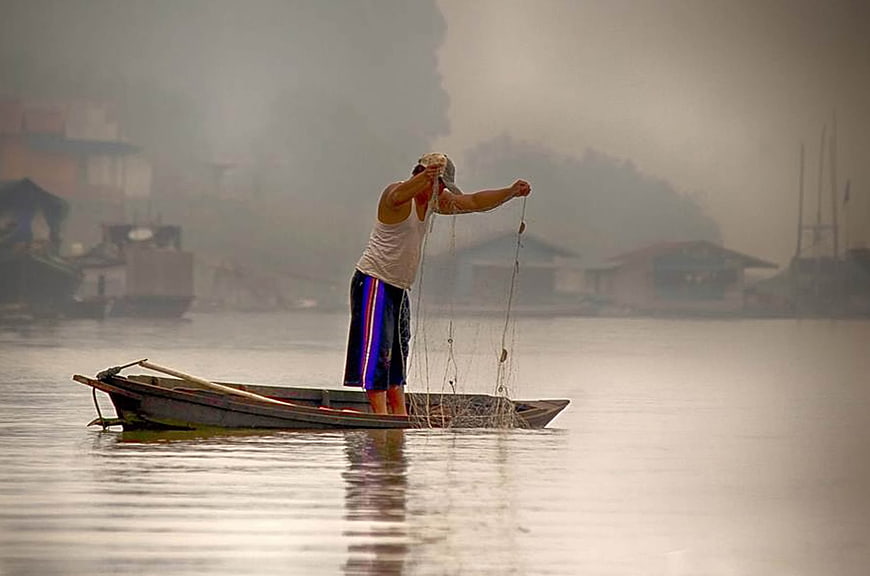 Fisherman Casting Net in Misty Morning River
