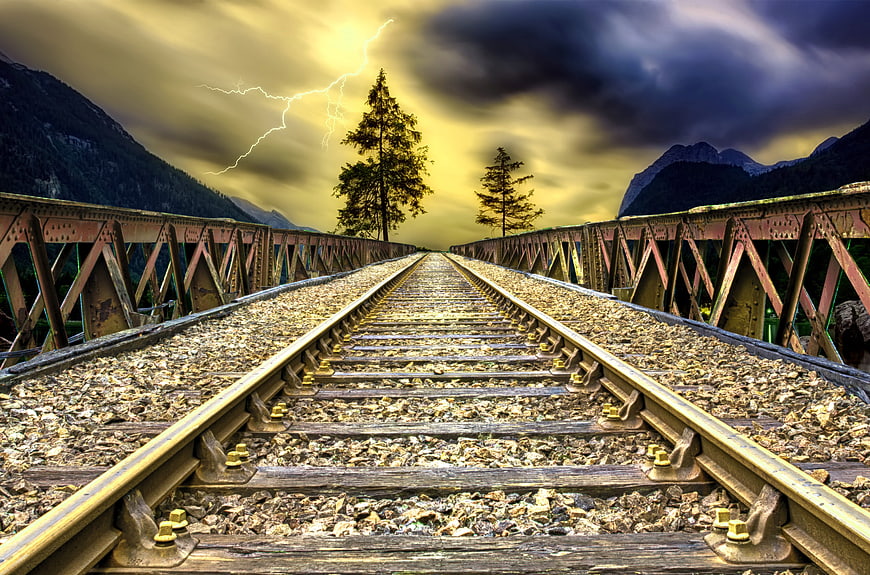 Dramatic HDR Railway Tracks on Bridge with Lightning Storm