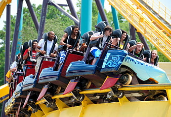 Excited Riders On A Blue And Red Roller Coaster Car