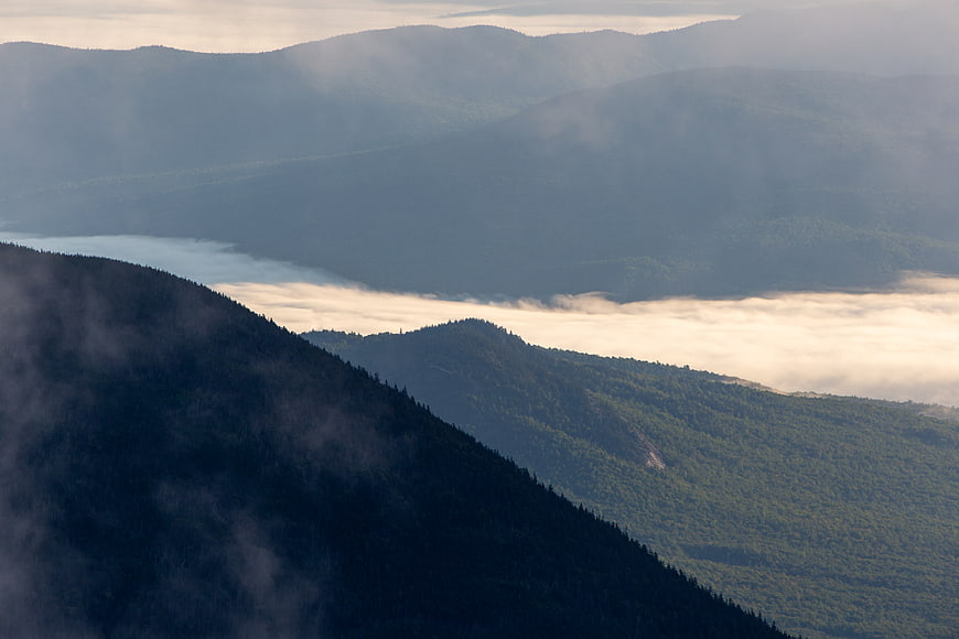 Misty mountain landscape with valley fog and forested slopes