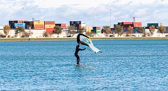 Kitesurfer on water with shipping containers background