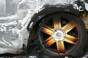 Burnt car wheel with heat discoloration and damaged body
