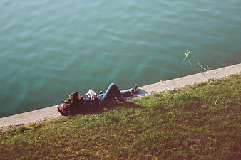 Woman Reading Book by Riverbank