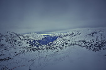 Snowy Mountain Landscape with Overcast Sky and Valley