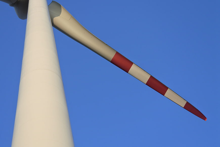 Low angle view of wind turbine blade against blue sky