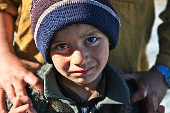 Close-up portrait of young boy in beanie looking at camera